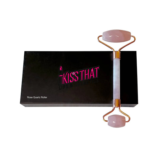 Rose quartz roller with gold accents on a black box labeled 'Kiss That Lips'.